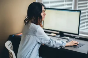 Collaboratrice al pc in azienda mentre gestisce il Campaign Manager su linkedIn | Postpickr