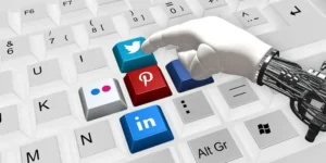 Una mano robotica sulla tastiera clicca su tasti con icone di social tra cui Pinterest | PostPickr